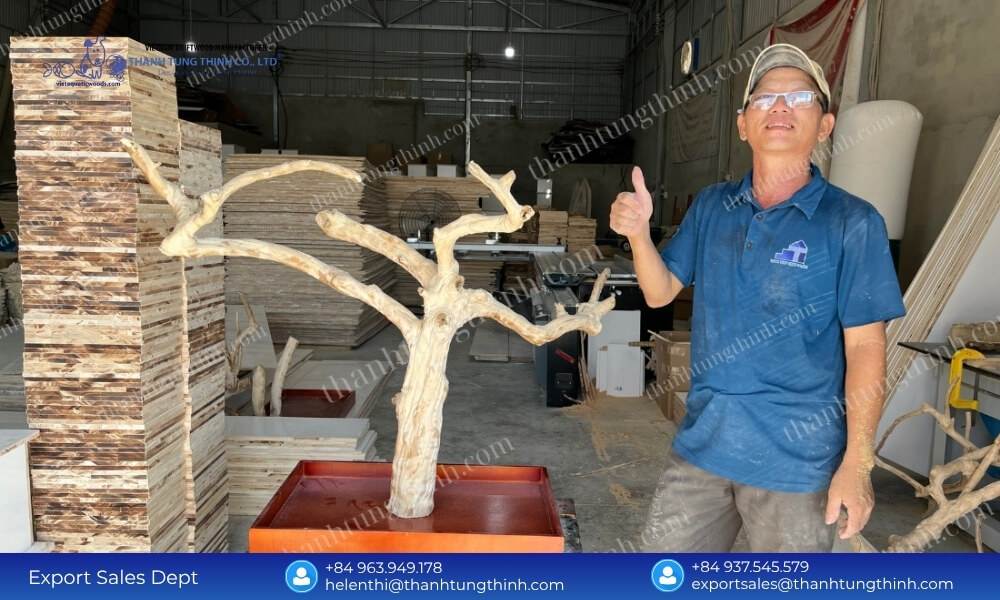 Factory worker giving a thumbs up next to a premium large coffee wood bird perch ready for export