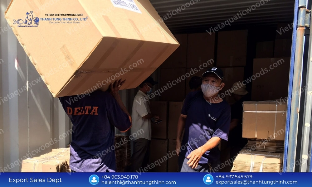 Workers loading flat packed boxes to maximize our wooden pet house factory monthly production capacity during FCL export
